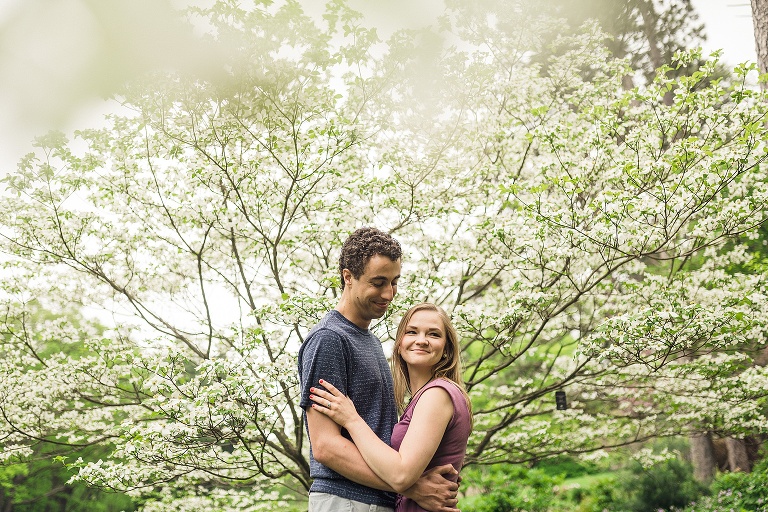 couple smiling in front of flowering tree at the Nichols arboretum