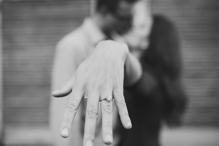 couple kissing and showing wedding ring