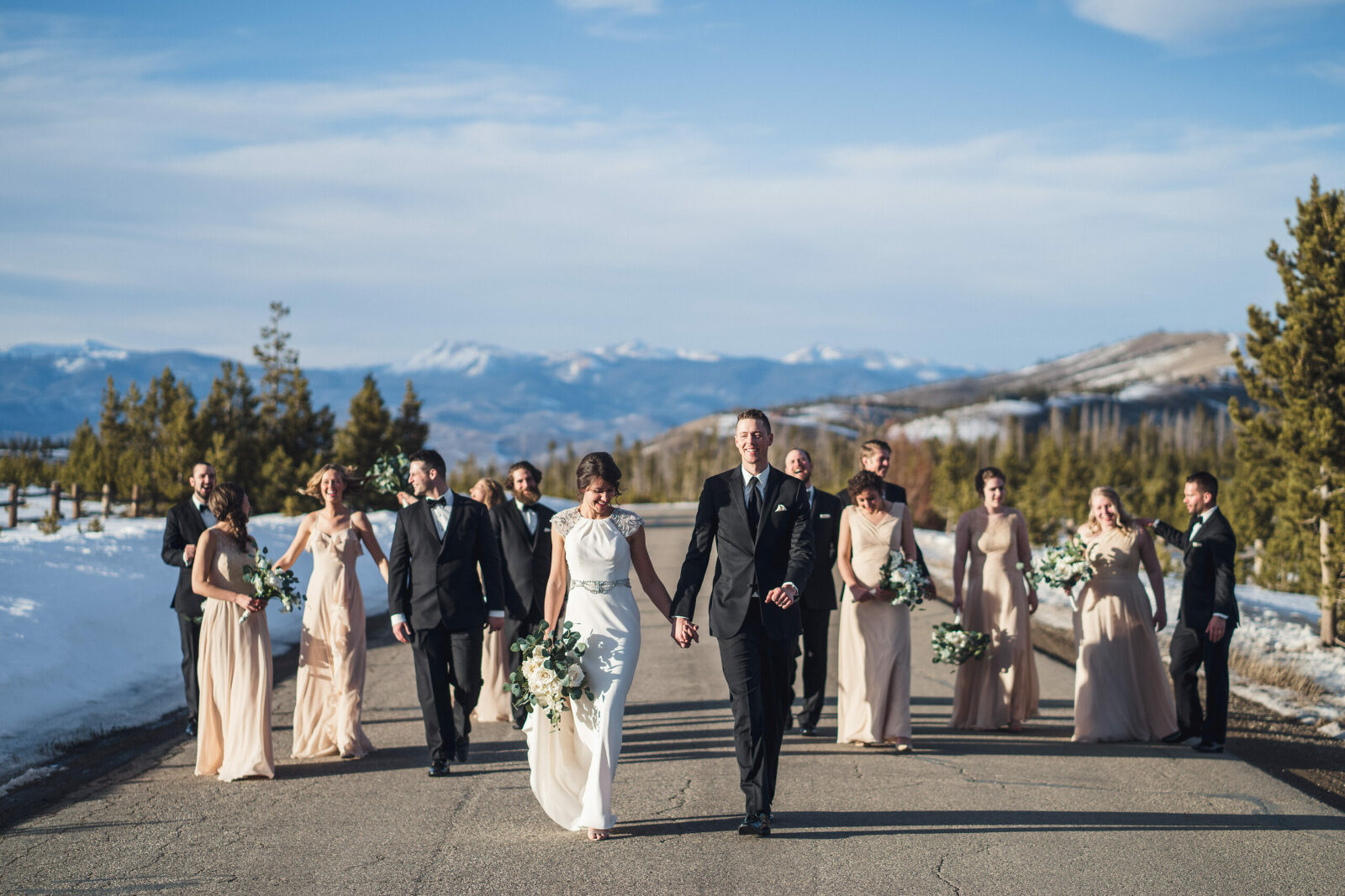 wedding party walking together on street in the snowy mountains of Colorado