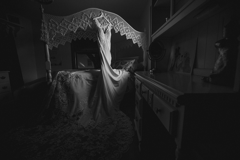 Wedding dress hanging in bedroom.