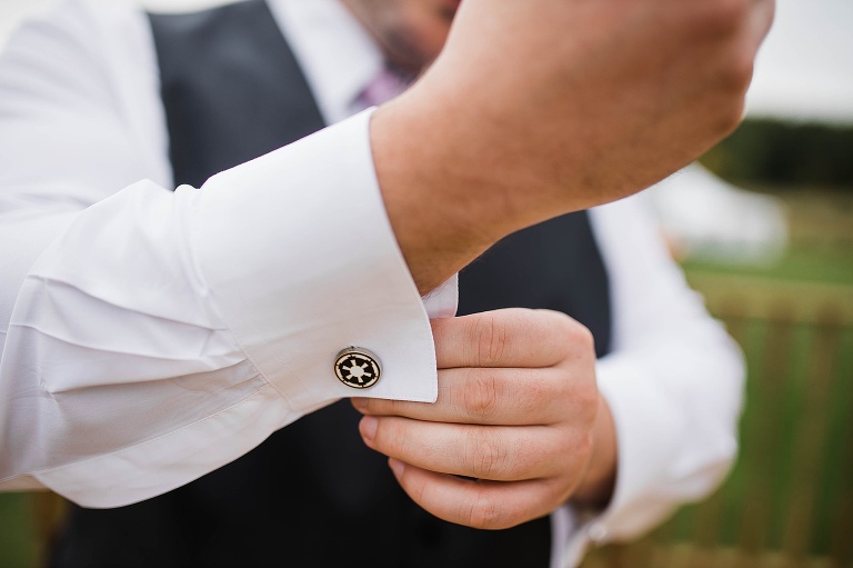 Groom getting ready putting on cuff links.