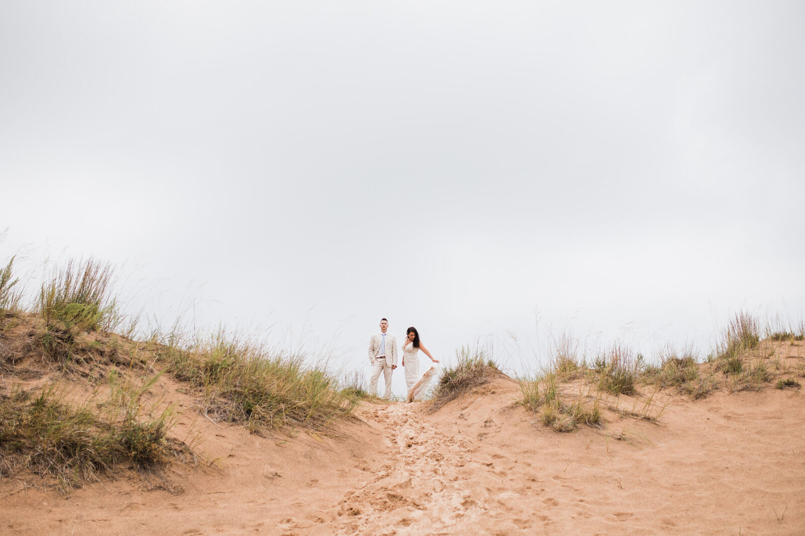 bride and groom on their wedding day in the sleeping bear dunes on Lake Michigan