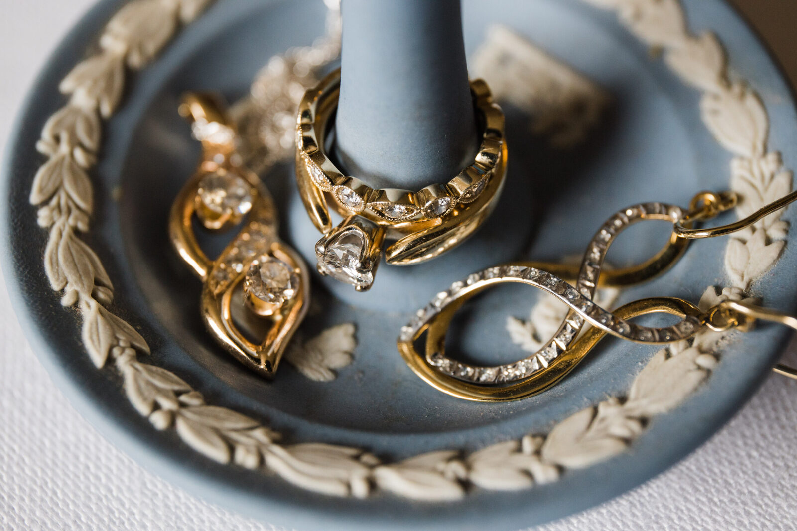 brides engagement ring and wedding jewelry on family heirloom dish